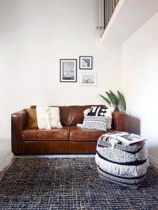 a living room with a brown leather couch and a rug at On the Duomo - Super Chic in Florence