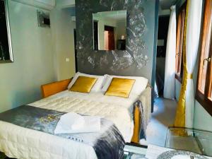 a bedroom with a bed with a mirror on the wall at Suite Dream on the River in Venice