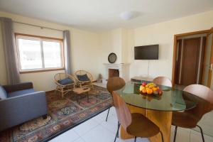 ein Wohnzimmer mit einem Tisch, Stühlen und einem Sofa in der Unterkunft Afife T2 - Bouça Cabrita Residence in Afife