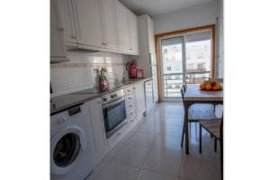 eine Küche mit einer Waschmaschine und einem Tisch in der Unterkunft Afife T2 - Bouça Cabrita Residence in Afife