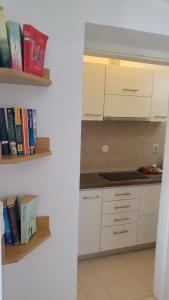 a kitchen with white cabinets and books at Nik 1 the Views Apartment in Dubrovnik