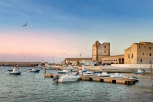 a group of boats are docked at a dock at La Tonnara di Bonagia Resort in Valderice