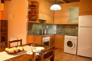 a kitchen with a table and a washer and dryer at Casa Ros in Agullo