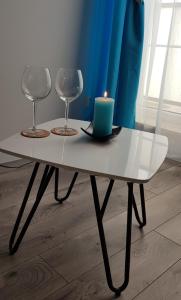 a table with two glasses and a candle on it at Apartament Wałowa Wejherowo in Wejherowo