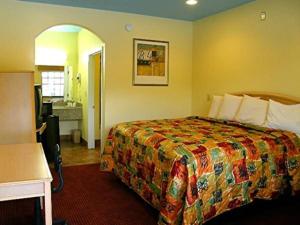 a hotel room with a bed and a bathroom at Matador Motel in San Antonio