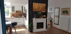 a living room with a fireplace and a kitchen at Margareta Home in Gyenesdiás