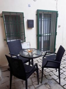 un patio con 2 sedie e un tavolo in vetro con sedie di La Rosa dei Sassi 2 a Matera