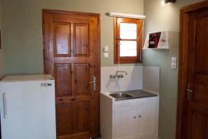 a kitchen with a white refrigerator and a sink at Mojito Elegant Studios in Plataniás