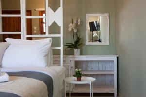 a bedroom with a bed and a mirror at Mojito Elegant Studios in Plataniás