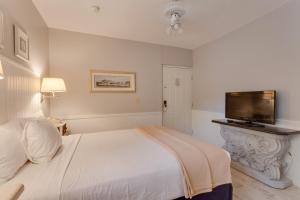 a bedroom with a bed and a flat screen tv at Lemon Tree Inn in Naples