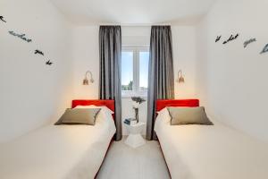 Duas camas sentadas uma ao lado da outra num quarto em Modern 4* luxury apartment in center em Trogir