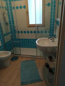 een badkamer met een wastafel, een toilet en een douche bij La Favola di Elsa in Castelsardo