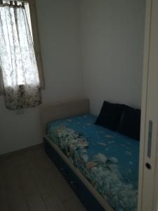 een kleine slaapkamer met een bed met een sprei van vis bij La Favola di Elsa in Castelsardo