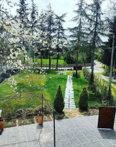 un giardino con un sentiero, alberi e fiori di Il Giardino Delle Noci a La Casinina