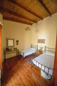 2 camas en una habitación con suelo de madera en ARCHANES APPARTMENT, en Archanes