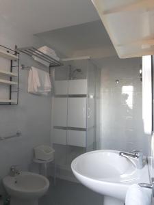 uma casa de banho com um lavatório, um chuveiro e um WC. em Il Grifo Camere e Suites em Grosseto