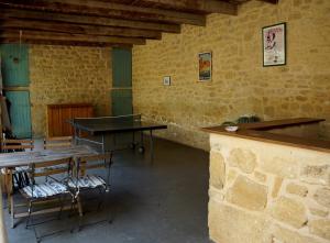 una habitación con mesas y sillas en un edificio en Mas Blauvac avec piscine, Entre Uzes Pont du Gard, en Vers Pont du Gard