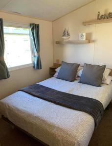 sypialnia z łóżkiem z niebieskimi poduszkami i oknem w obiekcie Edinburgh, seton sands w mieście Port Seton