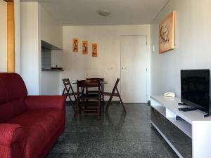 sala de estar con sofá rojo y mesa en Luzon Flat Meireles Praia, en Fortaleza