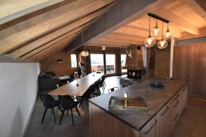 an open kitchen with a large island in a house at VAUJANYLOCATIONS - Chalet Opaline in Vaujany