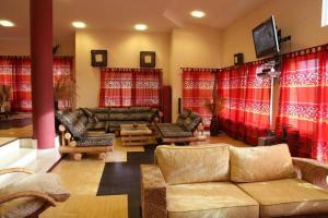 a living room with couches and red curtains at Ralitsa Guest House in Kyulevcha