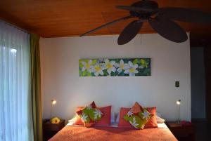 a bedroom with a bed with a ceiling fan at Marae - Cabañas Premium in Hanga Roa