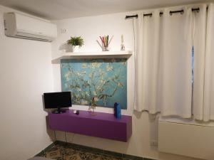 Pokój z purpurowym stołem z obrazem na ścianie w obiekcie Studio Bandiera apartment w mieście Palermo