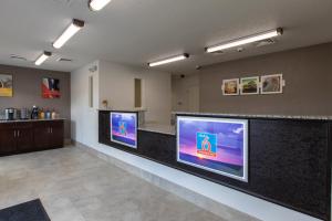 un vestíbulo con dos grandes monitores en un mostrador en Studio 6-Greenville, SC - I-85 Near Downtown en Greenville