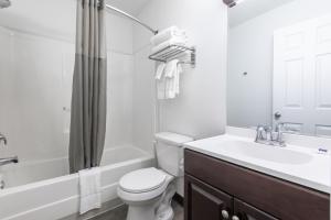 a bathroom with a toilet and a sink and a tub at Motel 6-Greenville, SC - I-85 Near Downtown in Greenville