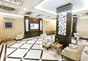 um átrio com uma sala de espera com cadeiras e uma televisão em Four Seasons Suites em Taif