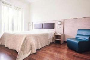a hotel room with a bed, chair and a television at Hotel Dei Sette in Vasto