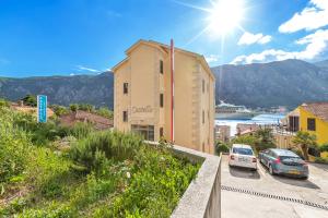 a building with cars parked in a parking lot at Apartments Castello in Kotor