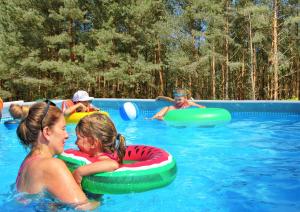 a group of children riding on inflatables in a swimming pool at Domki Fala in Dąbki
