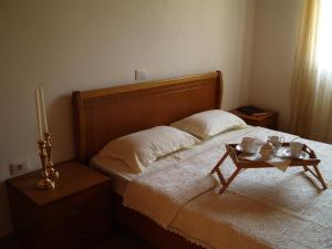 a bedroom with a bed with a wooden headboard and a table at Belvedere Adriatica in Qeparo