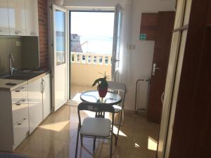a kitchen with a table and two chairs and a window at Studio Apartment Mala plaža in Kaštela