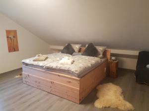 ein Schlafzimmer mit einem Holzbett mit Kissen in der Unterkunft Ferienwohnung Klothilde in Dietingen