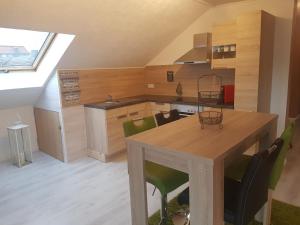eine Küche mit einem Holztisch und grünen Stühlen in der Unterkunft Ferienwohnung Klothilde in Dietingen