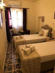 a hotel room with three beds with towels on them at Deniz Konak Boutique Hotel in Kyrenia
