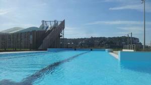 a large swimming pool with blue water in front of a building at L'ENTRE 2 COTES in Le Tréport