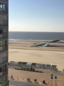 Blick auf einen Strand mit einem Gebäude und das Meer in der Unterkunft Residentie Paola in Ostende