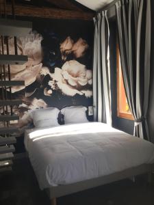 a bedroom with a bed with a wall with flowers at Room with a vue in Nice