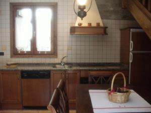 eine Küche mit Spüle und einem Tisch mit einem Korb in der Unterkunft La Corralata in Biescas