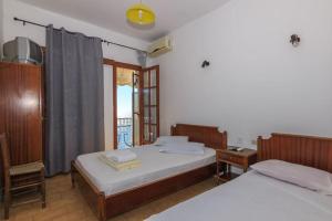 a bedroom with two beds and a window at VOULGARIS in Agios Georgios