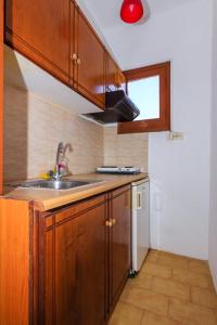 a kitchen with wooden cabinets and a sink and a window at VOULGARIS in Agios Georgios