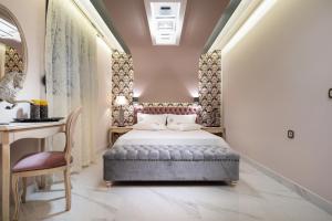 a bedroom with a bed and a desk and a chair at Pela Veranda Exquisite Suites in Neos Marmaras