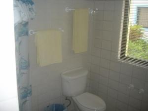 Beachfront apartment near Cabarete في كاباريتي: حمام مع مرحاض ونافذة ومناشف +39 صورة