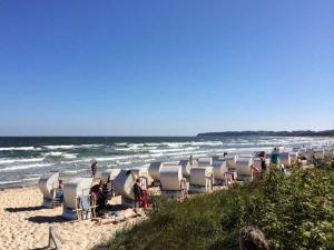 een rij stoelen op een strand naast de oceaan bij Ferienhaus Sonnensteg in Ostseebad Sellin