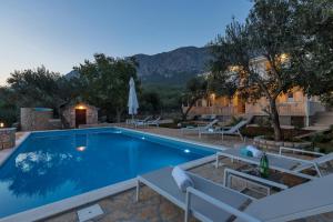 a pool at a hotel with chairs and a resort at Apartment Daria in Zaostrog