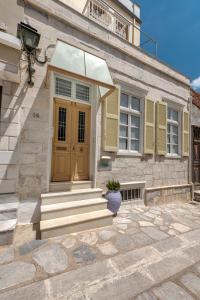 una casa con una puerta amarilla y unas escaleras en Island of Luxury Apartments, en Ermoupoli