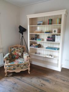 a chair in a room with a book shelf at Studio in Stijl in Apeldoorn